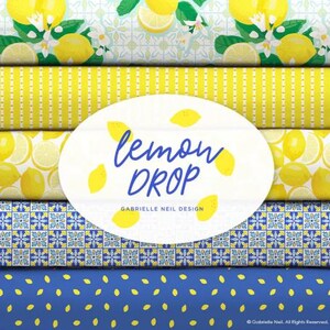 May include: A collection of five fabric patterns featuring yellow lemons, white blossoms, blue and white geometric tiles, and yellow stripes. A central white oval label displays the text "lemon DROP" in blue and "GABRIELLE NEIL DESIGN" in black.