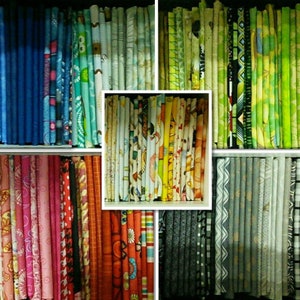 May include: A collection of fabric scraps organised by colour and pattern. The fabrics include blue, green, yellow, red, orange, pink, grey, and black. The fabrics are arranged in rows and columns, creating a visually appealing display.