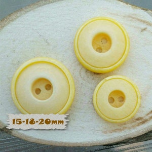 May include: Three yellow plastic buttons with two holes each. The buttons are 15-18-20mm in size.