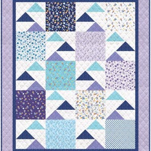 May include: A quilt with a white background and a patchwork design of blue, purple, and white fabric. The quilt features a variety of space-themed patterns, including stars, planets, and rockets.