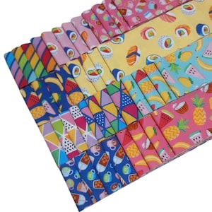 Peut inclure: Une pile de bandes de tissu colorées avec différents motifs, notamment des sushis, des fruits et des motifs géométriques. Le tissu est parfait pour le quilting, l'artisanat et d'autres projets de couture.