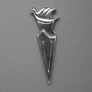 Peut inclure: Un ouvre-lettre argenté avec un motif d'oiseau. L'oiseau a des ailes et une tête détaillées. L'ouvre-lettre a une longue lame pointue avec deux lignes parallèles et de petits détails circulaires près du haut.