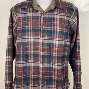 May include: A long-sleeved plaid shirt with a brown, red, green, and white plaid pattern. The shirt has a button-down collar and a button-up front.