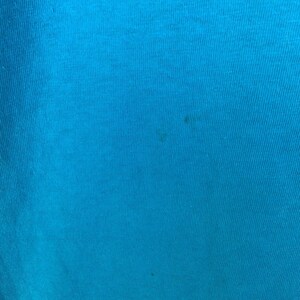 K&ouml;nnte beinhalten: Nahaufnahme eines leuchtend blauen Stoffes mit leicht strukturierter Oberfl&auml;che.