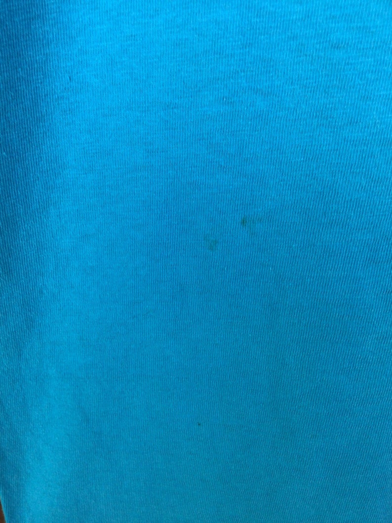 K&ouml;nnte beinhalten: Nahaufnahme eines leuchtend blauen Stoffes mit leicht strukturierter Oberfl&auml;che.