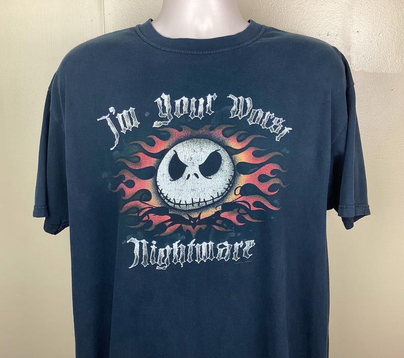 May include: Dark blue t-shirt featuring a graphic of Jack Skellington from The Nightmare Before Christmas. The design includes a skull with flames and the text "I'm your worst Nightmare".