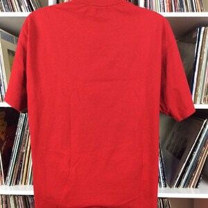 K&ouml;nnte beinhalten: Ein einfarbiges rotes T-Shirt auf einer Puppe. Das T-Shirt ist ein Basic-Modell mit kurzen &Auml;rmeln und einem Rundhalsausschnitt.