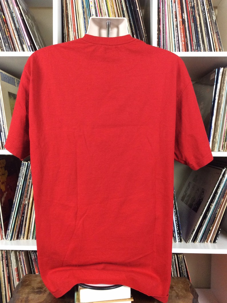 K&ouml;nnte beinhalten: Ein einfarbiges rotes T-Shirt auf einer Puppe. Das T-Shirt ist ein Basic-Modell mit kurzen &Auml;rmeln und einem Rundhalsausschnitt.