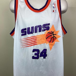 May include: White mesh basketball jersey with purple "SUNS" text, a basketball graphic, and the number 34 in purple. The jersey has orange and purple trim and a Champion logo.