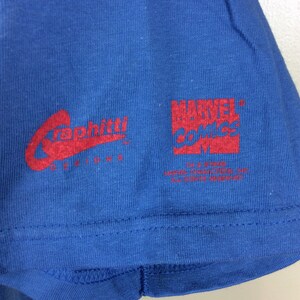 May include: A blue t-shirt with red text. The text reads "Graffiti Designs" and "Marvel Comics TM & &copy; 2003 Marvel Characters, Inc. All Rights Reserved."