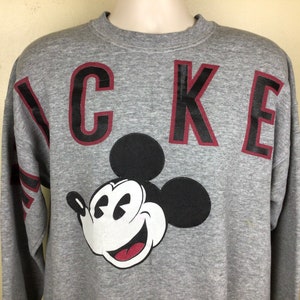 May include: Gray sweatshirt with a black and white Mickey Mouse graphic and the word "MICKEY" in red and black letters.