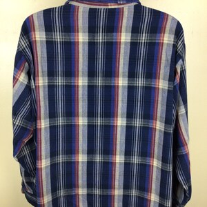 May include: A blue, red and white plaid long-sleeved shirt. The shirt has a button-down collar and a relaxed fit.