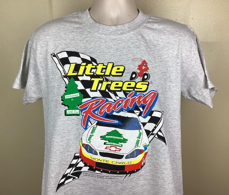 May include: Gray t-shirt with a graphic of a race car and the text "Little Trees Racing". The car is a red, white, and blue Monte Carlo with a green tree on the hood. The text is in black and white.