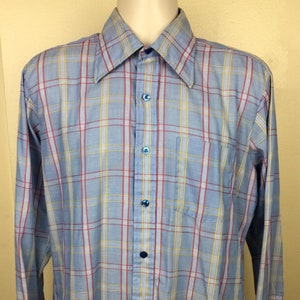 May include: A long-sleeved button-down shirt with a blue, red, and yellow plaid pattern.