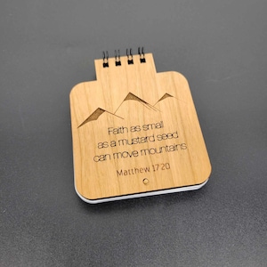 以下が含まれることがあります： 「マスタードの種ほど小さい信仰でも、山を動かすことができる。」マタイ17:20という聖書の言葉が書かれた木製メモ帳です。