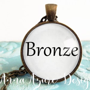 May include: A bronze pendant necklace with a round glass charm that says "Bronze" in black lettering.