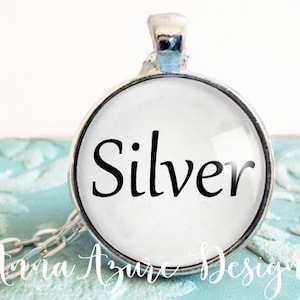 May include: A silver pendant necklace with a round glass charm that says "Silver" in black lettering.