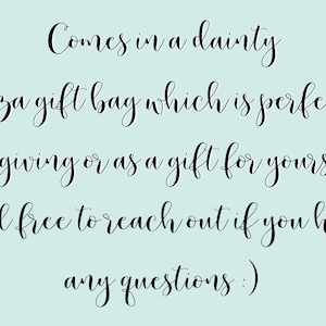 May include: Text in a cursive font reads: "Comes in a dainty organza gift bag which is perfect for gift giving or as a gift for yourself! Feel free to reach out if you have any questions :)"
