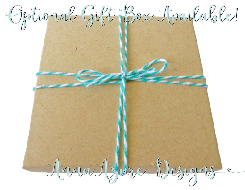 May include: A brown gift box tied with turquoise and white twine. The box is labeled "Anna Azure Designs".