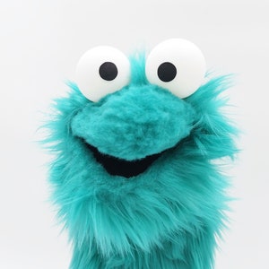 El pequeño Gustav, un títere turquesa que disfruta escuchando a Michael Buble y cultivando hortensias - títere, marioneta de mano