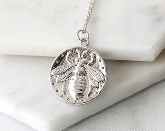Peut inclure: Collier en argent avec un pendentif rond représentant une abeille détaillée.