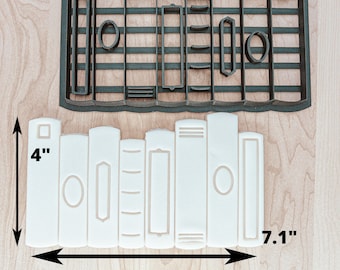May include: A white plastic cookie cutter shaped like a stack of books. The cutter is 7.1 inches wide and 4 inches tall.
