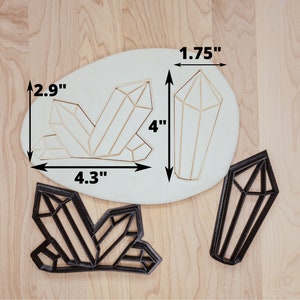 May include: A set of three cookie cutters shaped like crystals. The largest cutter is 4.3 inches wide and 2.9 inches tall. The medium cutter is 4 inches tall and 1.75 inches wide. The smallest cutter is 4 inches tall and 1.75 inches wide.