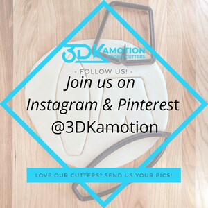 May include: A white diamond-shaped sign with a blue border on a wooden surface. The sign has the text "3DKamotion Cookie Cutters" and "Follow Us! Join us on Instagram & Pinterest @3DKamotion" in black text. The sign also has the text "Love our cutters? Send us your pics!" in black text.