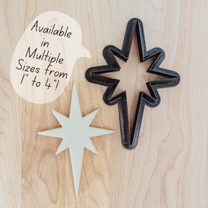 May include: Two star-shaped cookie cutters, one black and one white. The black cutter is larger than the white cutter. The text "Available in Multiple Sizes from 1" to 4"!" is written on a white speech bubble.