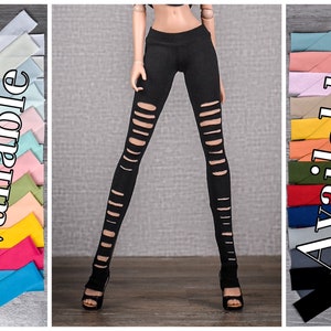 Op de afbeelding: Zwarte poppenlegging met distressed uitgesneden details. De afbeelding toont ook een verscheidenheid aan kleurrijke stoffen stroken, met het woord "Beschikbaar" in witte tekst. De legging wordt gecombineerd met zwarte sandalen met hoge hakken.