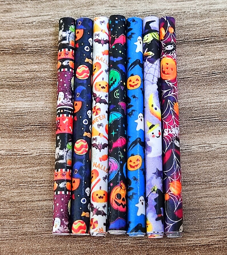 May include: Set of eight Halloween-themed straws with various designs, including bats, pumpkins, ghosts, and candy corn. The straws are black, blue, purple, and white.