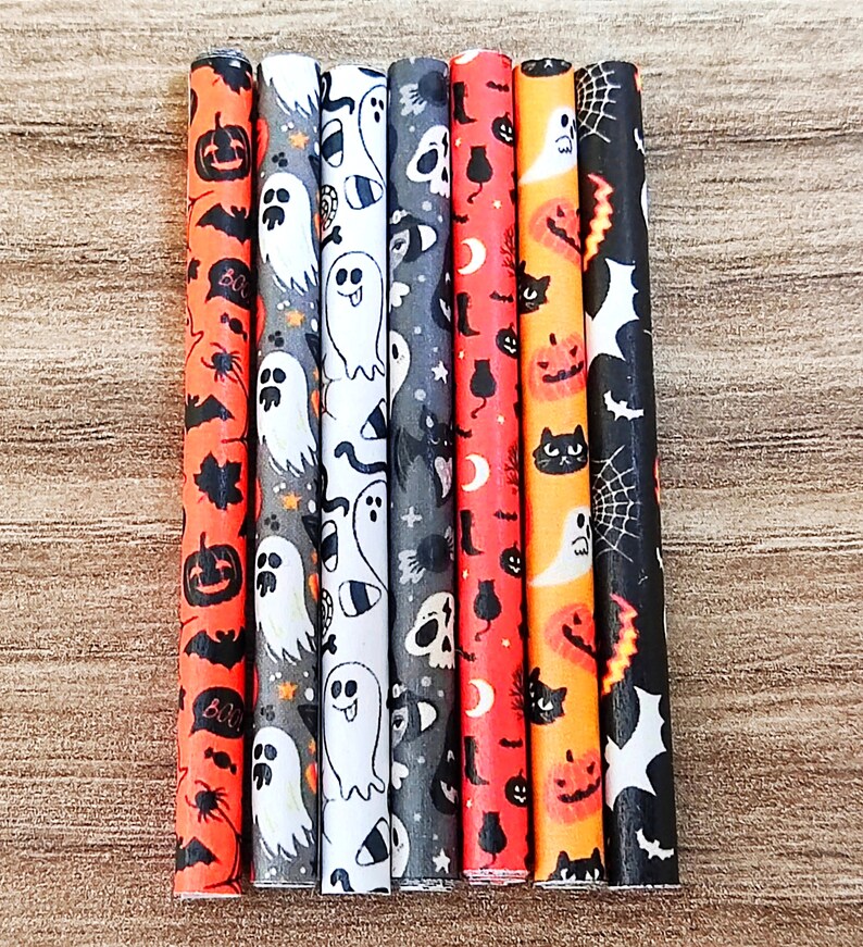 May include: Set of seven Halloween-themed straws with various patterns including ghosts, bats, spiders, pumpkins, and skulls. The straws are black and white with orange accents.