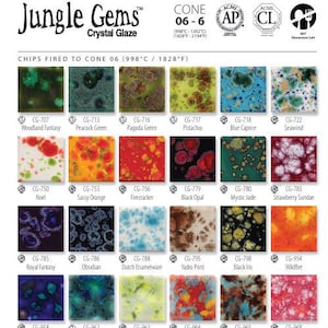 May include: A color chart of Jungle Gems Crystal Glaze ceramic glazes. The chart displays 24 unique glaze colors, each in a square tile. Colors range from green and blue to red and orange, with names like "Woodland Fantasy" and "Black Opal."
