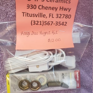 May include: A pink and white card with the text "B 'n' S Ceramics 930 Cheney Hwy Titusville, FL 32780 (321)567-3542 Kargi Tree Light Kit $12.00" and a white electrical cord with a plug and a light bulb.