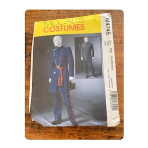 Puede incluir: Patrón de disfraces McCall's para un uniforme de estilo militar. La portada del patrón presenta un maniquí con un abrigo azul con botones dorados, una faja roja y pantalones a juego. El número de patrón es M4745.