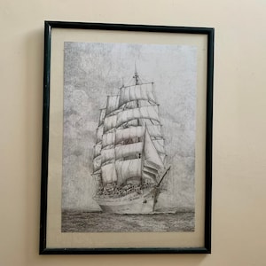 May include: A black and white framed print of a ship with sails. The ship is sailing on a calm sea with a cloudy sky in the background.