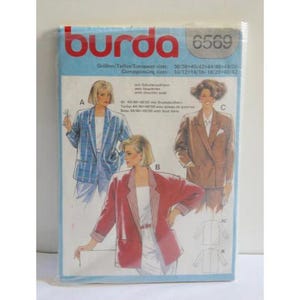 Op de afbeelding: Een Burda 6569 naaipatroonpakket. Het pakket bevat illustraties van vrouwen die blazers dragen in blauw, bruin en rood. Het Burda-logo is rood en het pakket heeft een blauwe achtergrond. Het pakket bevat ook maatvoering.