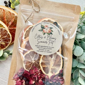 Pu&ograve; includere: Un sacchetto di carta marrone con una finestra di plastica trasparente, contenente frutta di agrumi secca, petali di rosa e bacche di ginepro. Un adesivo rotondo sul sacchetto recita "Citrus & Blooms Simmer Pot" con istruzioni per l'uso: "Aggiungere tutti gli ingredienti in una pentola, Aggiungere 2-3 tazze d'acqua, Far sobbollire a fuoco lento, Aggiungere acqua se necessario".