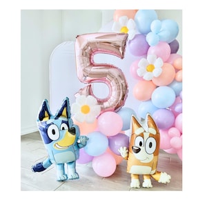May include: A pink foil number 5 balloon surrounded by pastel colored balloons and a white flower. Two cartoon dog characters, one blue and one brown, are in the foreground.
