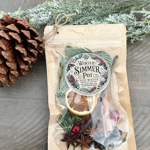 Pu&ograve; includere: Un sacchetto di carta marrone con una finestra di plastica trasparente, contenente un mix di frutta secca, spezie ed erbe. Il sacchetto &egrave; legato con uno spago e ha un'etichetta che recita "Winter Simmer Pot" con istruzioni per aggiungere acqua e far sobbollire a fuoco lento.