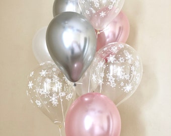 May include: A bouquet of balloons in silver, white, and pink. Some of the balloons have a snowflake pattern.