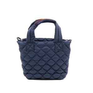 May include: Navy blue quilted tote bag with a diamond pattern. The bag has two short handles and a detachable shoulder strap. The handles have a colorful accent. The bag is approximately 9 inches wide and 8 inches tall.