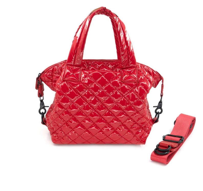 K&ouml;nnte beinhalten: Eine gl&auml;nzende rote Handtasche mit einem Steppmuster. Die Tasche hat zwei obere Griffe und einen abnehmbaren Schultergurt. Die Hardware ist schwarz. Die Tasche befindet sich auf wei&szlig;em Hintergrund.