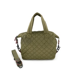 May include: A quilted green handbag with a top handle and a detachable shoulder strap. The bag has a zipper closure and a diamond pattern.