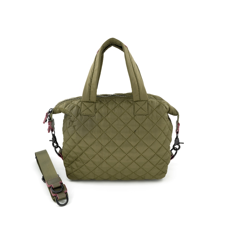 May include: A quilted green handbag with a top handle and a detachable shoulder strap. The bag has a zipper closure and a diamond pattern.