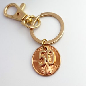 May include: Gold key chain with a 1974 penny featuring the number 50 on it.