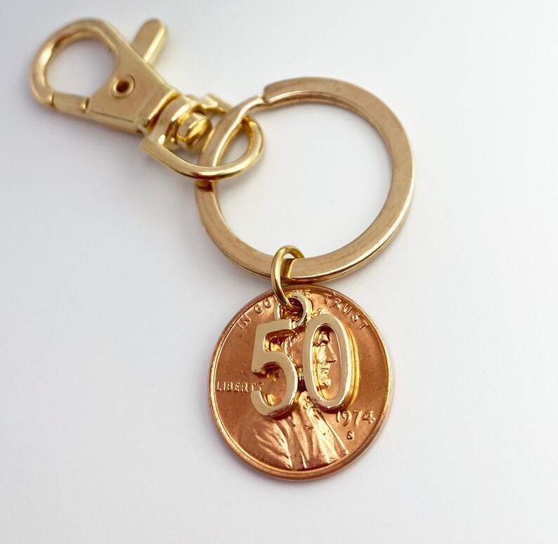 May include: Gold key chain with a 1974 penny featuring the number 50 on it.