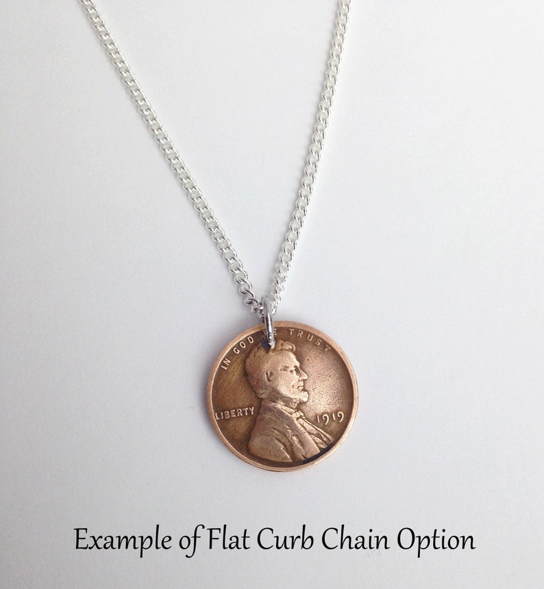 May include: A silver chain necklace with a 1919 penny pendant. The penny features a profile of Abraham Lincoln with the words "In God We Trust" and "Liberty" on the coin.