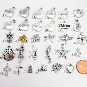 May include: Assortment of silver and gold charm pendants with various designs and words, including "daughter", "sister", "aunt", "mom", "niece", "son", "brother", "uncle", "dad", "friend", "best friends", "love you to the moon and back", "you are loved", "love", and more.