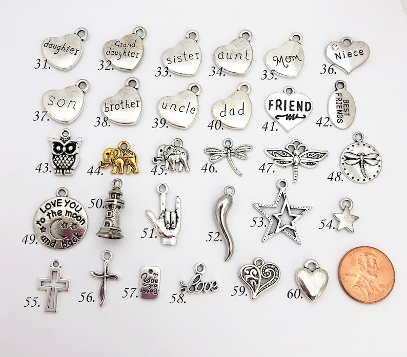 May include: Assortment of silver and gold charm pendants with various designs and words, including "daughter", "sister", "aunt", "mom", "niece", "son", "brother", "uncle", "dad", "friend", "best friends", "love you to the moon and back", "you are loved", "love", and more.